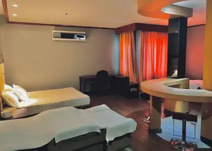 image depicts a dimly lit, spacious room that appears to be a hotel room or a similar accommodation