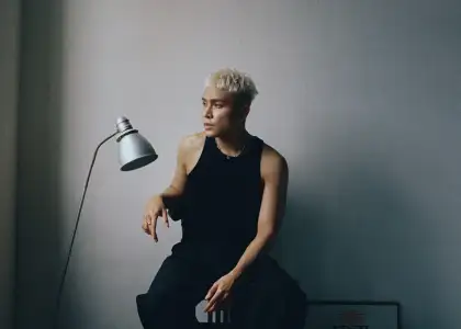 Firdhaus with blond hair in a black tank top