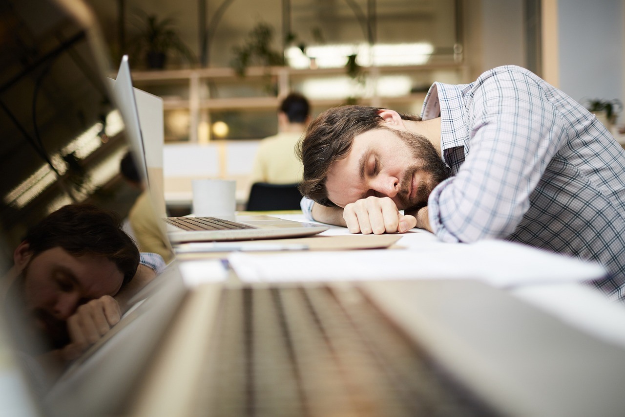 man sleeping on work desk