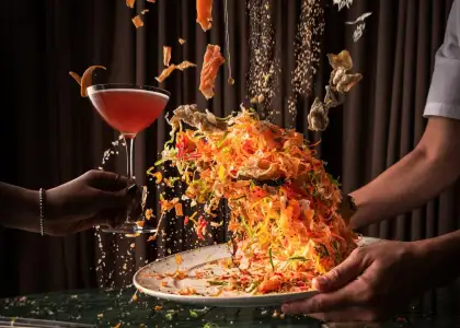 A dramatic, dynamic, and brightly lit close-up shot captures a culinary performance.