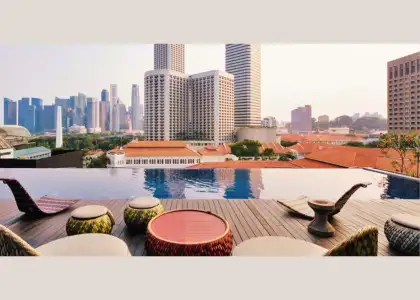City skyline visible from the rooftop pool at the Naumi Hotel highlighting urban architecture and a sunny atmosphere.